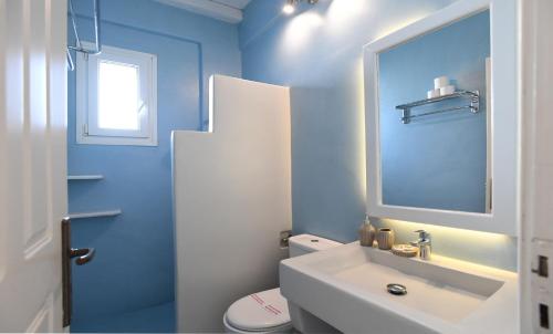 a blue bathroom with a sink and a toilet at Nostos Beachfront Apartments & Studios in Agios Ioannis