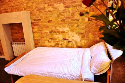 a bed in a room with a brick wall at Kyiv Volcano Studio in Kyiv