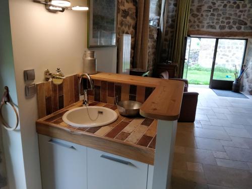 a bathroom with a sink with a wooden counter top at Les Fayettes in Montregard