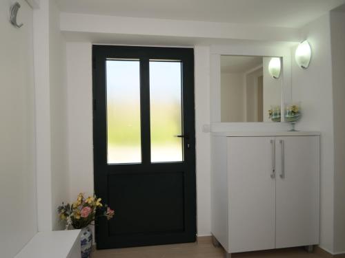 uma porta preta num quarto branco com um espelho em Apartments Kordić em Kotor