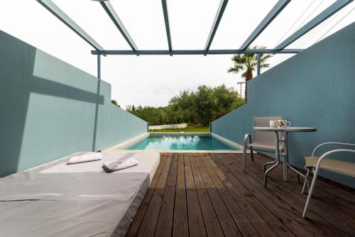 a bedroom with a bed and a table and a pool at Zante Calinica Hotel in Tsilivi