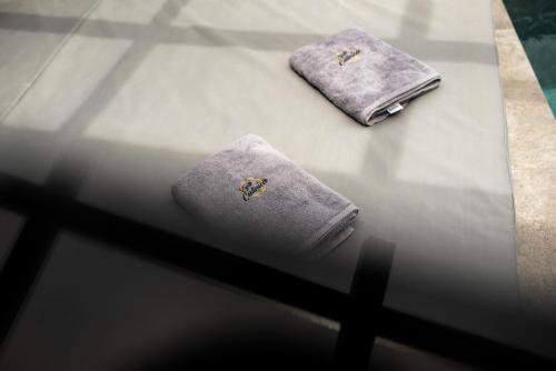 two towels are sitting on a glass table at Zante Calinica Hotel in Tsilivi