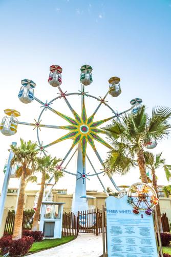 a ferris wheel in a park with palm trees at Rixos Premium Seagate in Sharm El Sheikh
