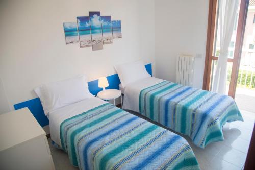 una camera con due letti con lenzuola a righe di Summer by the sea home a Cavallino-Treporti