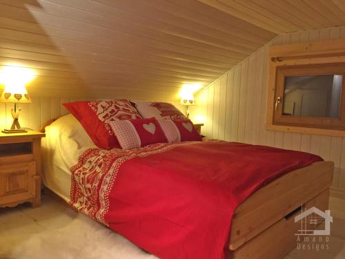 a bedroom with a bed with red pillows at Le Mazot de la Fis in Chamonix-Mont-Blanc