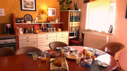 cocina con mesa de madera con sillas y mesa en La Hulotte en Limogne-en-Quercy