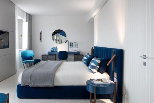 a bedroom with a blue bed and blue chairs at Hotel Plaza e de Russie - Relais & Châteaux in Viareggio
