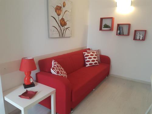 a red couch in a living room with a table at La Casa di Charme in Ragusa