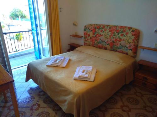 a bedroom with a bed with two towels on it at Hotel la Maggioressa in Ischia