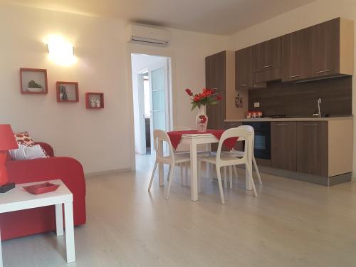 a kitchen and a living room with a table and chairs at La Casa di Charme in Ragusa