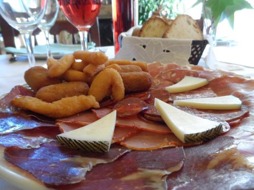 a plate of food with cheese and meat and other foods at La Casa del Filandón- HOTEL RURAL in Quintanilla de Somoza