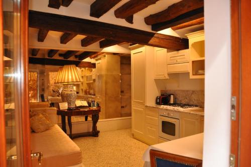 威尼斯的住宿－亨利的天堂公寓，一间厨房,内设白色橱柜和一张桌子