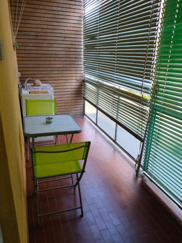 a table and two chairs in a room with windows at A CASA DI GIANCARLA in Bologna