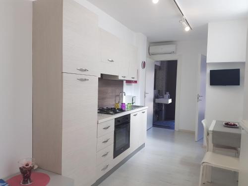 a kitchen with white cabinets and a stove top oven at La Casa di Charme in Ragusa
