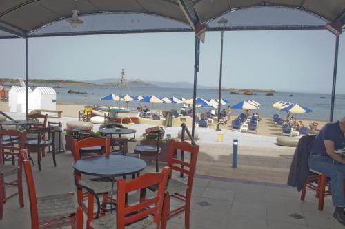 a beach with tables and chairs and people on the beach at Danaos Hotel in Chania