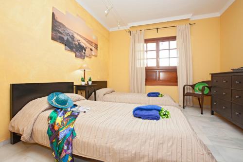 2 letti in una camera da letto con pareti gialle di Villa Hortensia a Playa Blanca