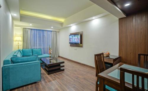 a living room with a blue couch and a table at Regenta Central Srinagar, Rajbagh in Srinagar