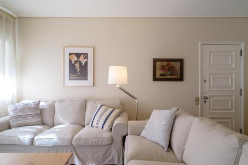 a white living room with a couch and a table at APA 12 in Espinho