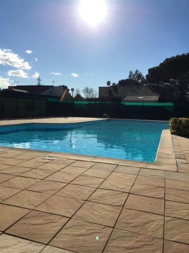 una piscina de agua azul en un patio en Résidence le Clos Azur 115, en La Motte