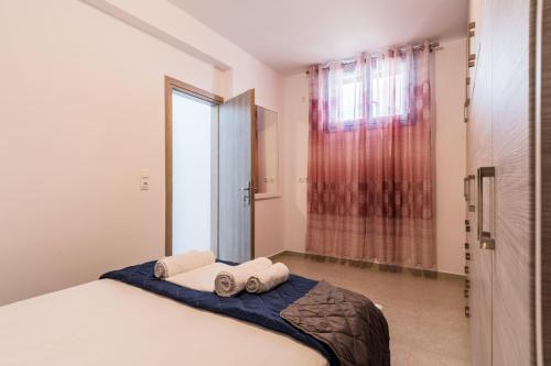 a bedroom with a bed with two towels on it at Adelphi Apartments in Perissa