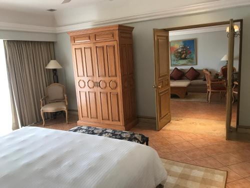 a bedroom with a bed and a large wooden cabinet at Grand Isla Navidad Golf & Spa Resort with Marina in Barra de Navidad