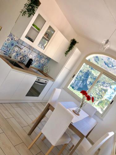 a dining room with a table and chairs and a window at Sky House Amalfi Coast in Scala