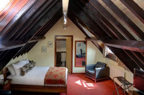a bedroom with a bed and a chair at Best Western Henbury Lodge Hotel in Bristol