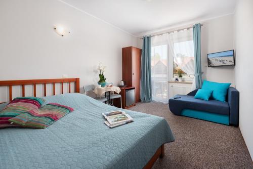 1 dormitorio con 1 cama azul y 1 sofá azul en Pasja Jastrzębia Góra, en Jastrzębia Góra
