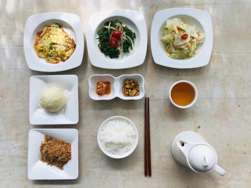 a table with plates of food and bowls of ingredients at Jia's Homestay in Lugu