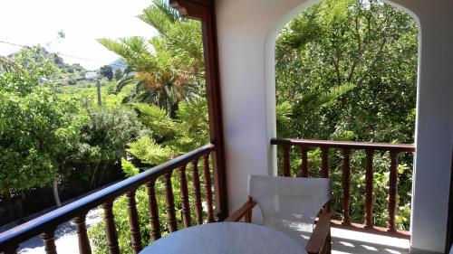 a balcony with a table and a window with trees at Villa Christina in Tolo