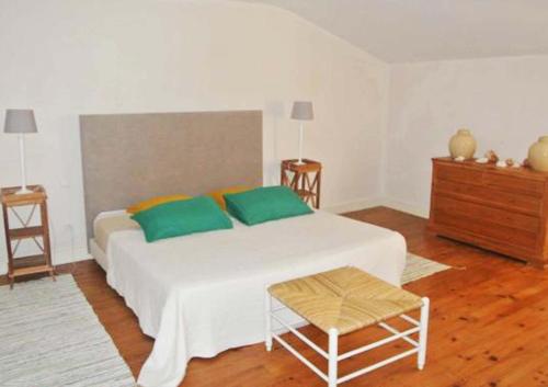 een slaapkamer met een groot wit bed met groene kussens bij Garros in Fronsac