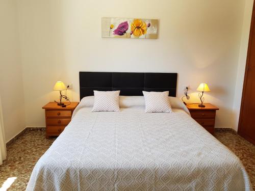 a bedroom with a large bed with two night stands at Casa Sol in Santa Eularia des Riu
