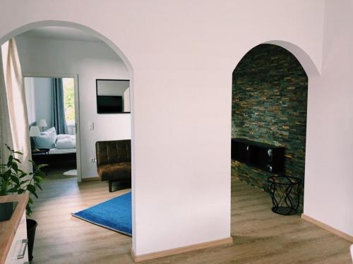 einen Torbogen in einem Wohnzimmer mit einem gemauerten Kamin in der Unterkunft Aurora Schaar 2 in Wilhelmshaven