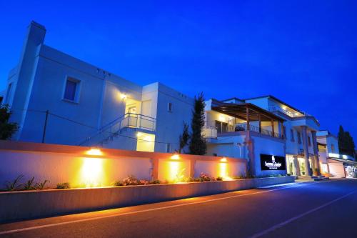 a white building with lights on the side of a street at Summer Garden Suites Beach Hotel in Bitez