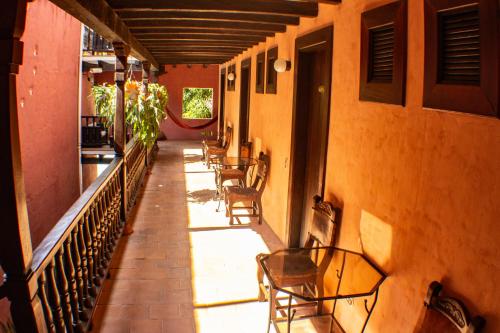 a hallway with chairs and tables on a building at Casa Hotel Guaracú in Santa Fe de Antioquia
