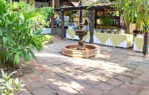 a fountain in the middle of a patio with tables and chairs at Casa Hotel Guaracú in Santa Fe de Antioquia