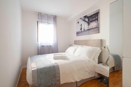 Un dormitorio blanco con una cama y una ventana. en Ve.N.I.Ce Cera Ca'Amata, en Venecia