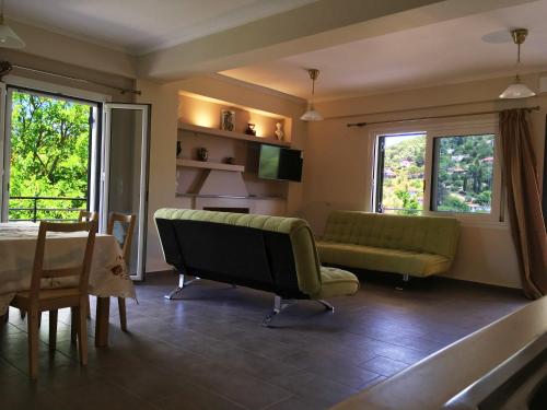 ein Wohnzimmer mit einem Sofa und einem Tisch in der Unterkunft Tsoutsis Apartments in Marantochori