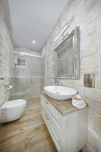 a white bathroom with a sink and a mirror at Holiday Home Petar in Drage