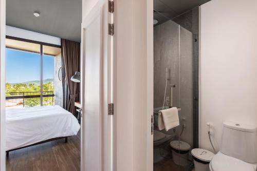 a hotel room with a bed and a bathroom at Lucky Holidays in Saturdays Residence in Rawai Beach