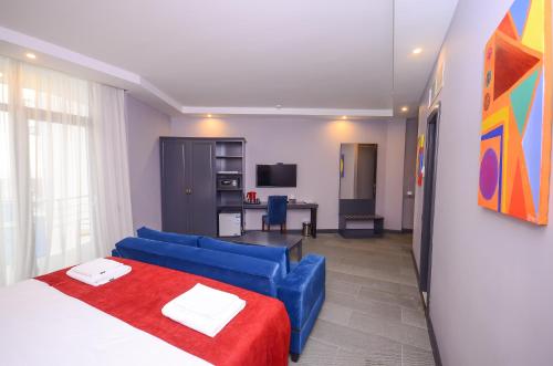 a bedroom with a blue couch and a living room at Batumi Palm Hotel in Batumi