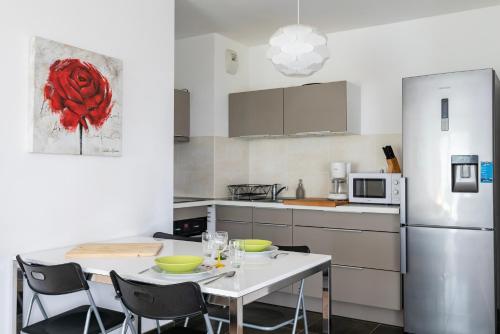 a kitchen with a table and chairs and a refrigerator at CityCosy Strasbourg - Neudorf Garden Bucarest in Strasbourg