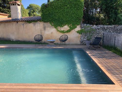 - une piscine avec des chaises et une table dans la cour dans l'établissement Maison centre ville UZES, à Uzès