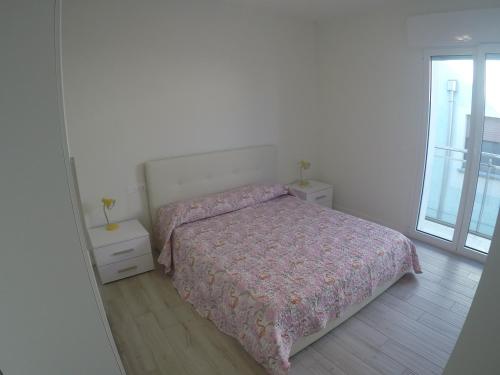 a bedroom with a bed and a large window at New Alfieri - Agenzia Cocal in Caorle