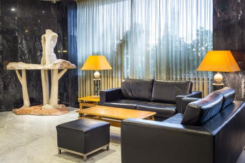 a living room with couches and a table and a statue at Radisson Blu Hotel Lisbon in Lisbon