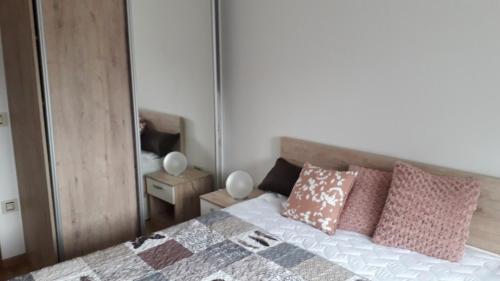a bedroom with a bed with pillows and a mirror at Apartman Nana Svetogorska 19 ,stan 17 in Zlatibor
