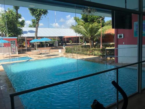 a view of a swimming pool through a window at Hotel Cabana in Teresina