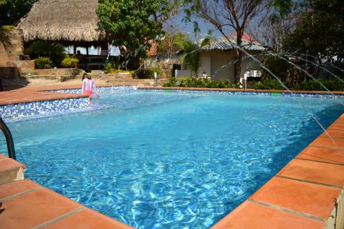 a woman standing next to a swimming pool at Casa en Santa Veronica Atlantico in Santa Veronica
