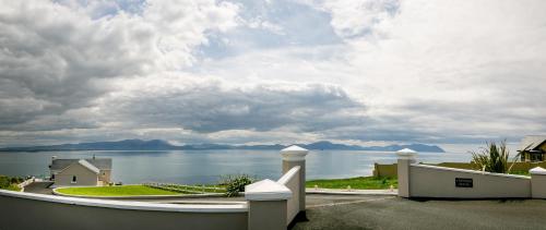 a view of the water from a house with a fence at Ballyheigue Cliff Side and Sea View Apartment in Ballyheigue