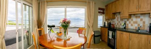 a kitchen with a table with flowers on it at Ballyheigue Cliff Side and Sea View Apartment in Ballyheigue